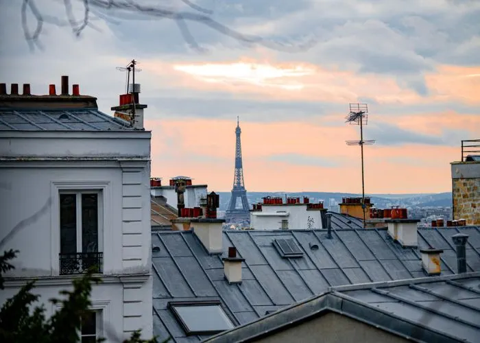 Toits parisiens et tour Eiffel au coucher du soleil